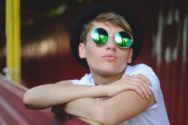 Retrato de mujer hipster con maquillaje natural y corte de pelo corto disfrutando del tiempo libre al aire libre