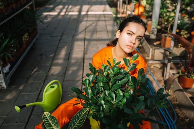 Retrato de una mujer jardinero con planta en maceta