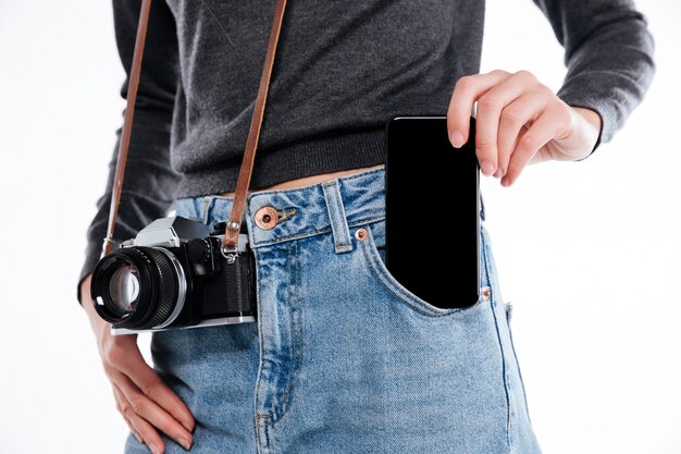 Retrato de una mujer en jeans con cámara retro