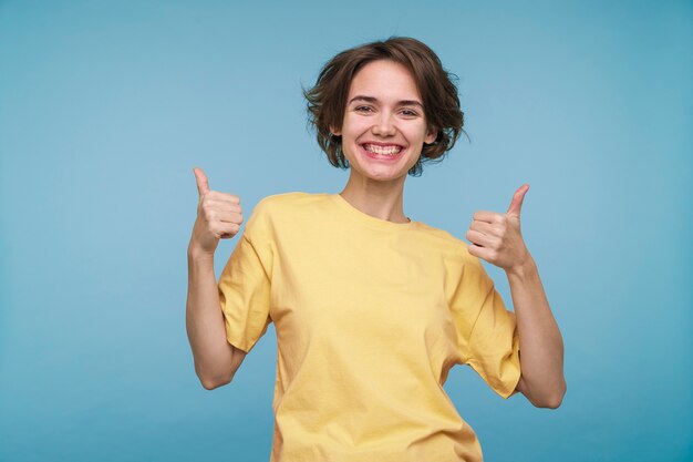 Retrato, de, un, mujer joven, actuación, pulgares arriba