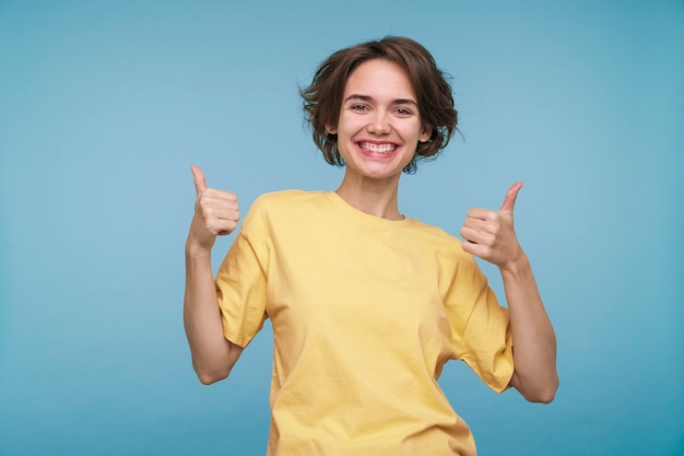 Retrato, de, un, mujer joven, actuación, pulgares arriba