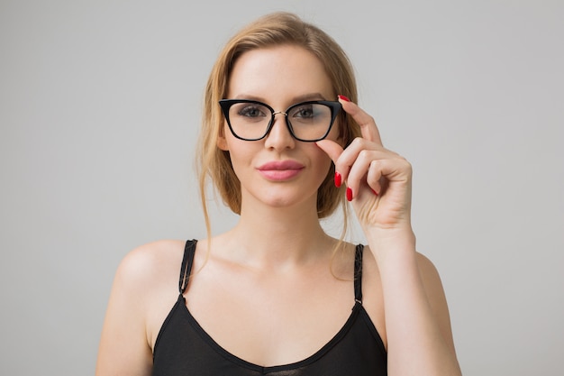 Foto gratuita retrato de mujer joven aislada en blanco con gafas en pose de confianza y vistiendo un vestido negro