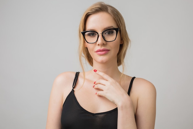 Retrato de mujer joven aislada en blanco con gafas en pose de confianza y vistiendo un vestido negro