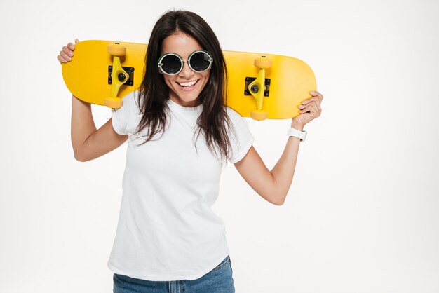 Retrato de una mujer joven alegre con patín