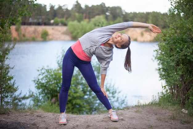 Retrato de mujer joven alegre que dobla al aire libre