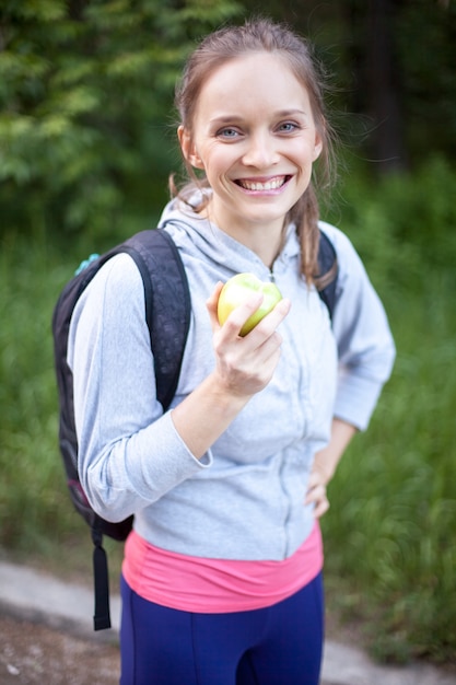 Retrato de mujer joven alegre sosteniendo la manzana