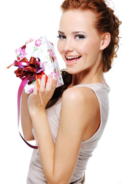 Retrato de una mujer joven de alegría feliz con un regalo en sus manos