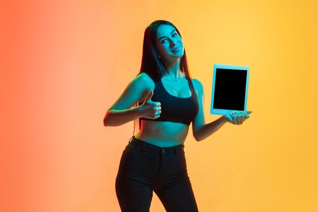 Retrato de mujer joven en amarillo-naranja en luz de neón