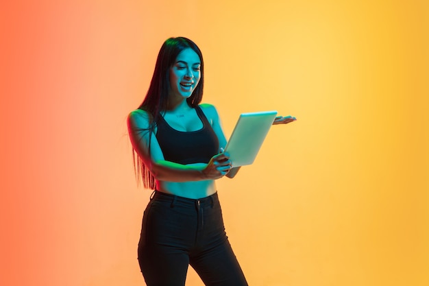 Retrato de mujer joven en amarillo-naranja en luz de neón