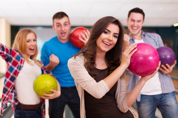 Retrato de mujer joven con amigos en la bolera