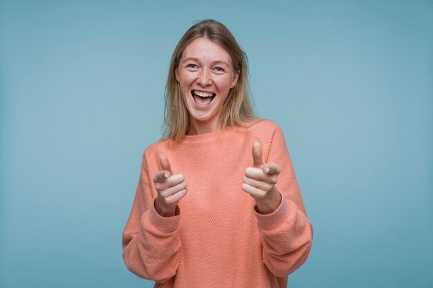 Retrato de una mujer joven apuntando con una actitud genial