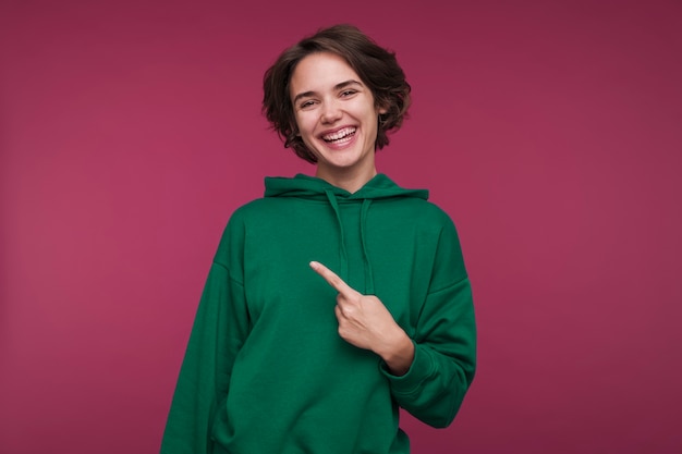 Retrato de una mujer joven apuntando a algo