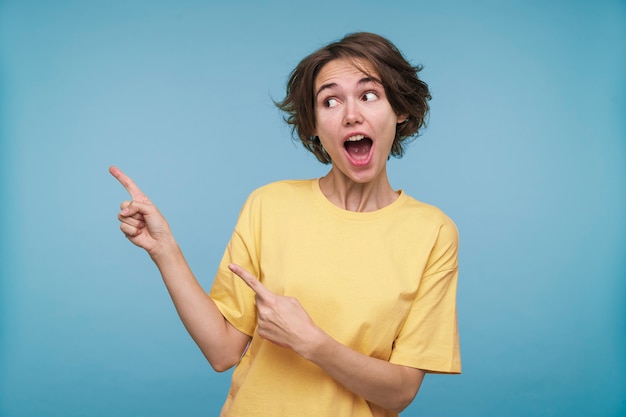 Retrato de una mujer joven apuntando a algo