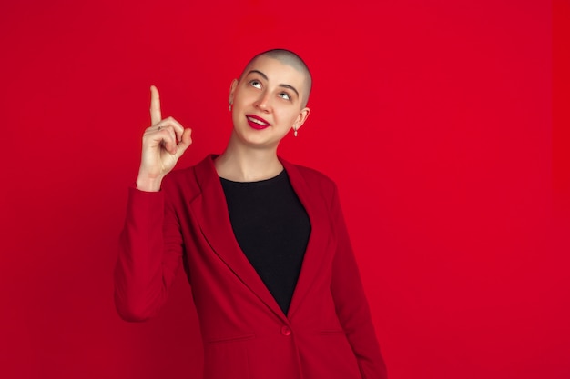 Retrato de mujer joven con aspecto extraño en la pared roja