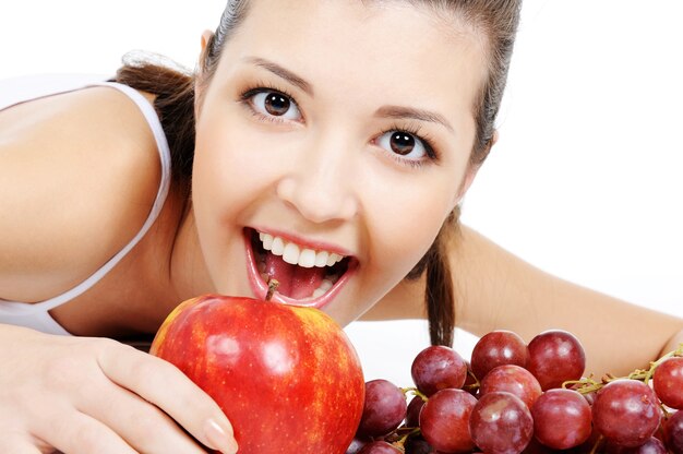 Retrato de mujer joven atractiva expresiva con manzana y uvas