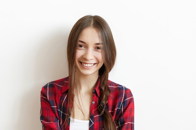 Retrato de mujer joven atractiva y feliz con trenza desordenada y hermosa sonrisa encantadora