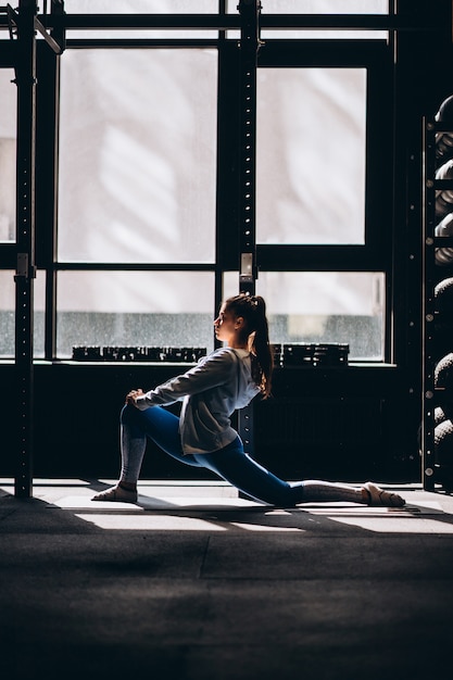 Retrato de mujer joven atractiva haciendo ejercicios de yoga o pilates