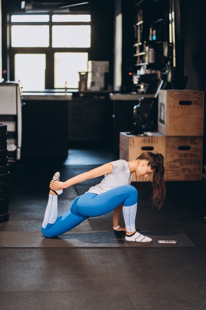 Retrato de mujer joven atractiva haciendo ejercicios de yoga o pilates