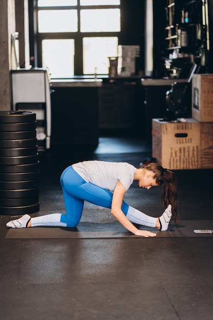 Retrato de mujer joven atractiva haciendo ejercicios de yoga o pilates