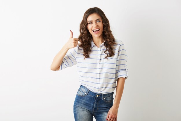 Retrato de mujer joven y atractiva vestida de casual con expresión facial emocionada, mostrando un gesto positivo, sonriente, feliz, estilo hipster, aislado, rizado, pulgar hacia arriba, delgado, hermoso, mirando a puerta cerrada