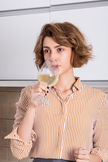 Retrato de una mujer joven bebiendo el vino