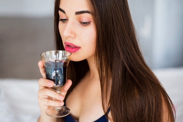 Retrato mujer joven bebiendo vino