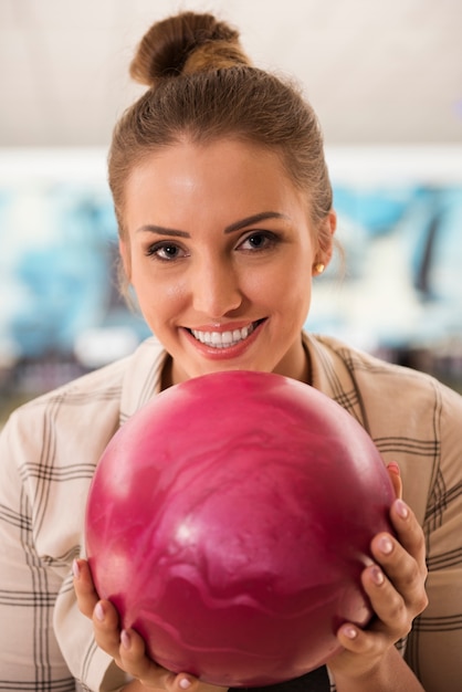Retrato de mujer joven con bola de boliche rosa