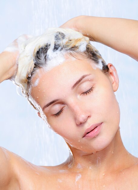 Retrato de mujer joven y bonita lavándose el pelo