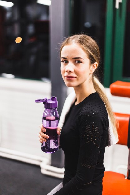 Retrato de una mujer joven con botella de agua