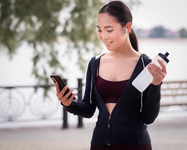 Foto gratuita retrato de mujer joven con botella de agua