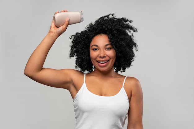 Retrato de mujer joven con botella de loción corporal