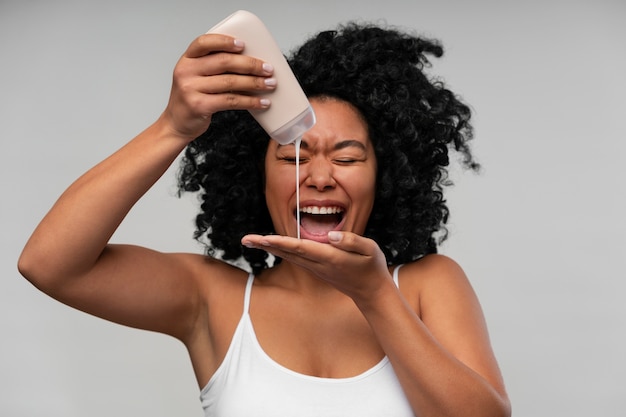 Retrato de mujer joven con botella de loción corporal