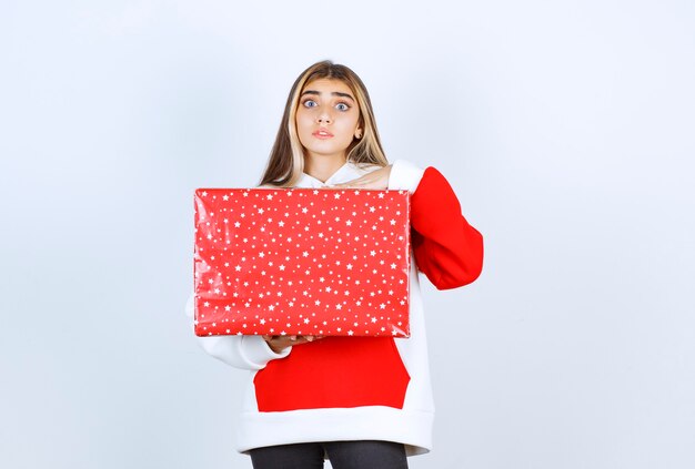 Retrato, de, mujer joven, en, cálido, suéter, tenencia, regalo de navidad