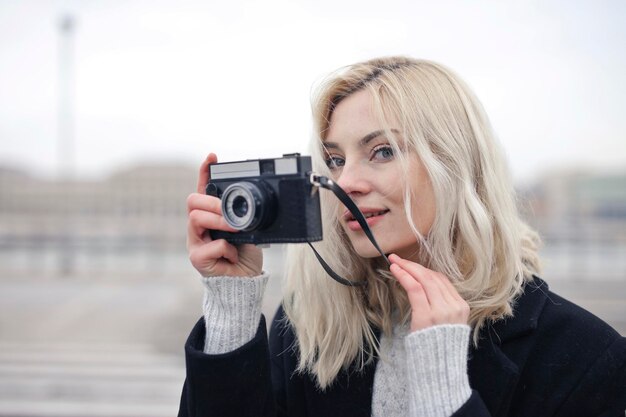 retrato de mujer joven con una cámara vintage