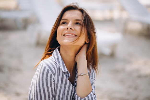 Retrato de una mujer joven en camisa en la playa