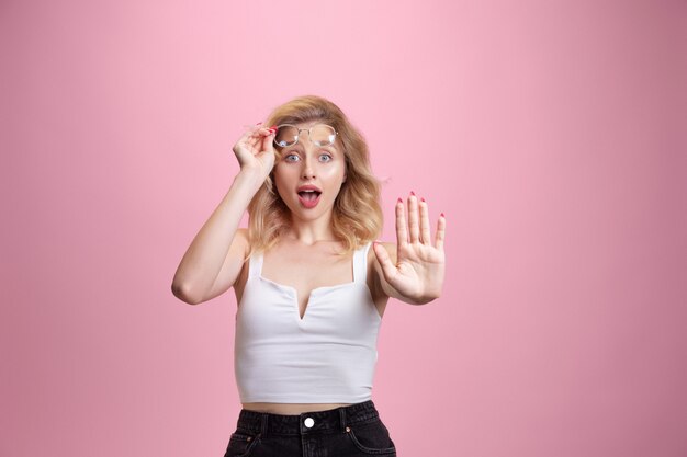 Retrato de mujer joven caucásica aislado en estudio rosa