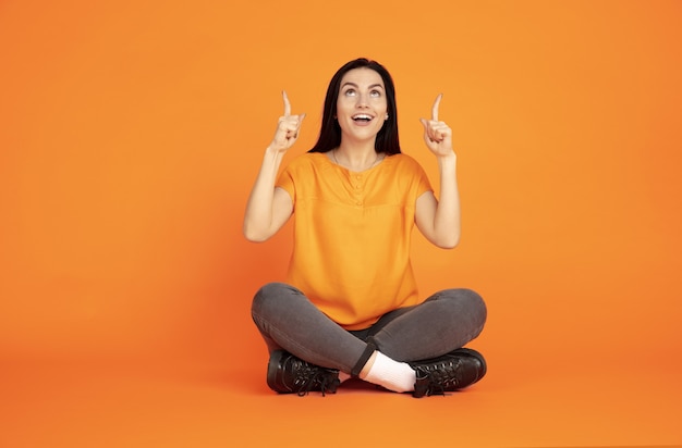 Retrato de mujer joven caucásica en naranja