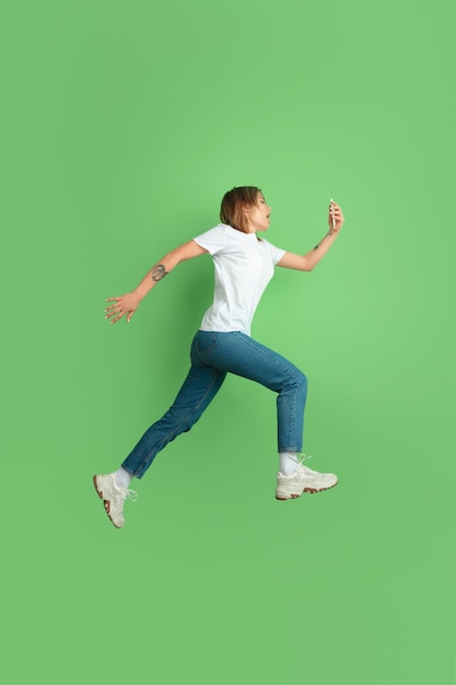 Retrato de mujer joven caucásica en la pared verde del estudio