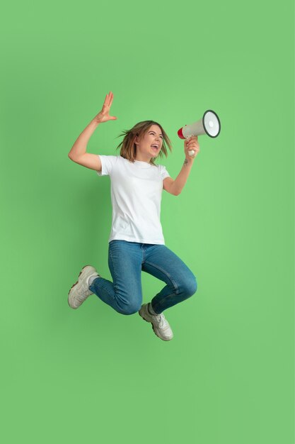 Retrato de mujer joven caucásica en la pared verde del estudio