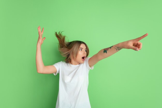 Retrato de mujer joven caucásica en pared verde