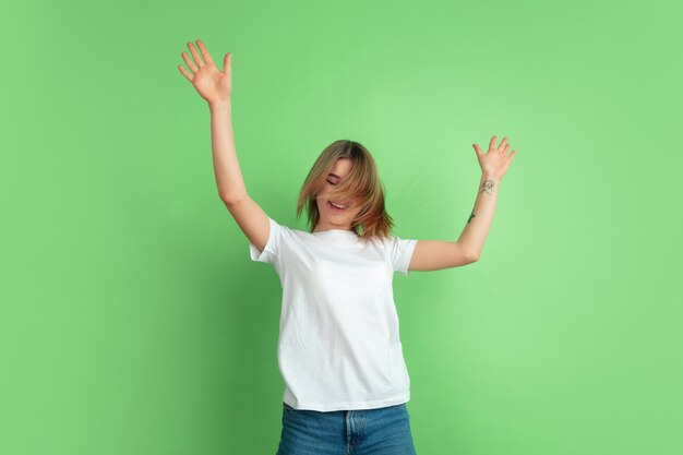 Retrato de mujer joven caucásica en pared verde