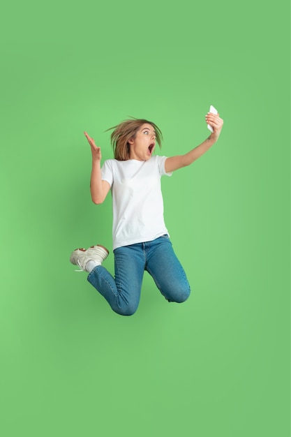 Foto gratuita retrato de mujer joven caucásica en pared verde