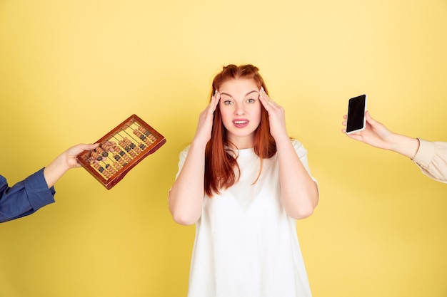 Retrato de mujer joven caucásica sobre fondo amarillo, demasiadas tareas