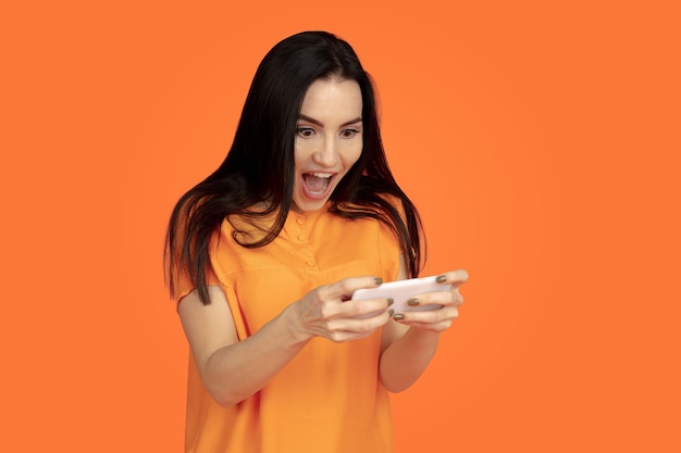 Foto gratuita retrato de mujer joven caucásica sobre fondo naranja