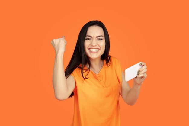 Retrato de mujer joven caucásica sobre fondo naranja