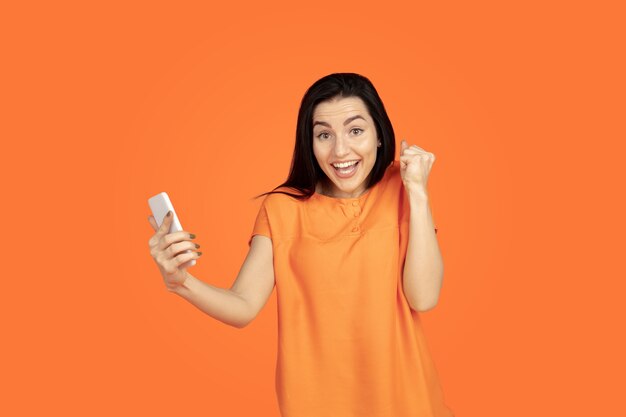 Retrato de mujer joven caucásica sobre fondo naranja