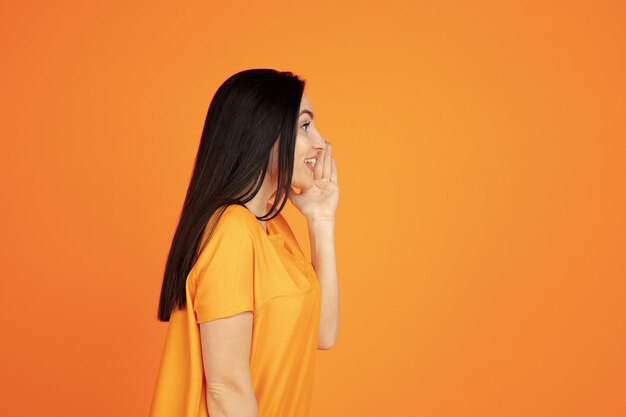 Retrato de mujer joven caucásica sobre fondo naranja