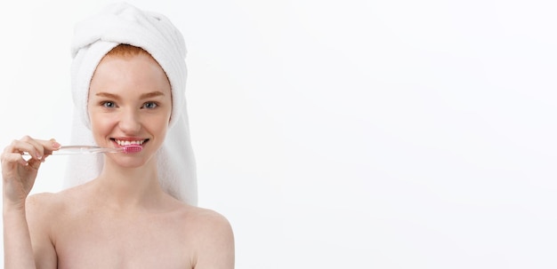 Retrato de mujer joven con cepillo de dientes sobre fondo gris