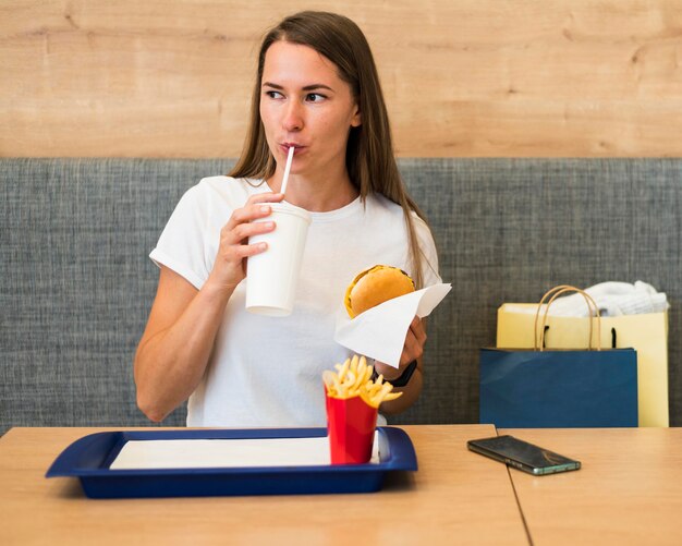 Retrato de mujer joven comiendo comida rápida