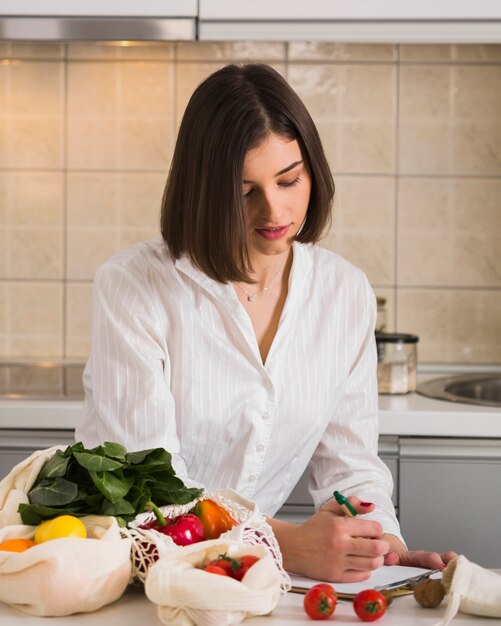 Retrato de mujer joven comprobando la lista de compras